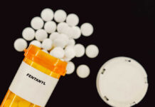 Mind-Boggling Fentanyl Haul: 100 Million Lives At Risk! Prescription bottle of fentanyl tablets scattered on surface