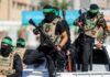 Masked men with firearms standing on a vehicle