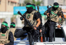 Masked men with firearms standing on a vehicle