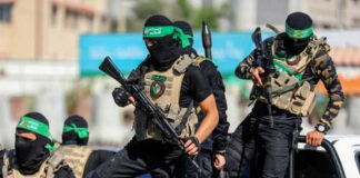 Masked men with firearms standing on a vehicle