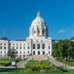 Historic white capitol building under clear blue sky