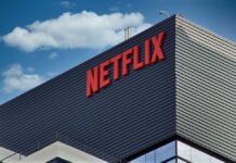 Close-up of the Netflix logo on a modern building against a blue sky