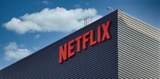 Close-up of the Netflix logo on a modern building against a blue sky