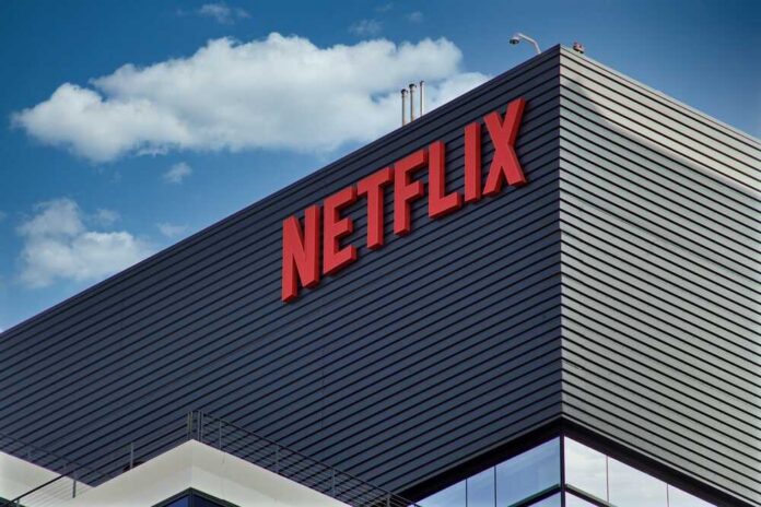 Close-up of the Netflix logo on a modern building against a blue sky