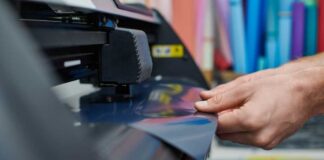 Person operating a vinyl cutter in a creative workspace