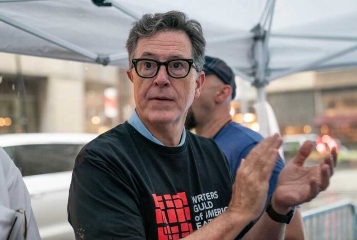 Stephen,Colbert,Serves,Ice,Cream,To,Striking,Members,Of,Writers Person clapping at a protest wearing a Writers Guild of America t-shirt