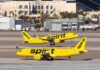 Two Spirit Airlines planes on a runway at an airport