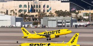 Two Spirit Airlines planes on a runway at an airport