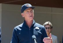 A government official speaking at a press conference outdoors