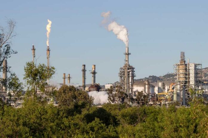 Wilmington,,Ca,,Usa,-,May,13,,2022:,Exterior,View,Of Industrial refinery with smoke stacks and flames against a clear sky