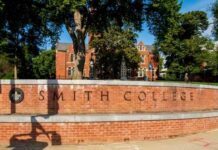 Sign for Smith College in front of a brick building surrounded by trees