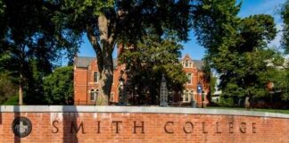 Sign for Smith College in front of a brick building surrounded by trees