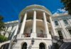 Exterior view of the White House with columns and blue sky