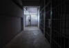 Antisemitic Theories from SF Jail Official – Unbelievable! A dimly lit prison corridor with jail cells on either side