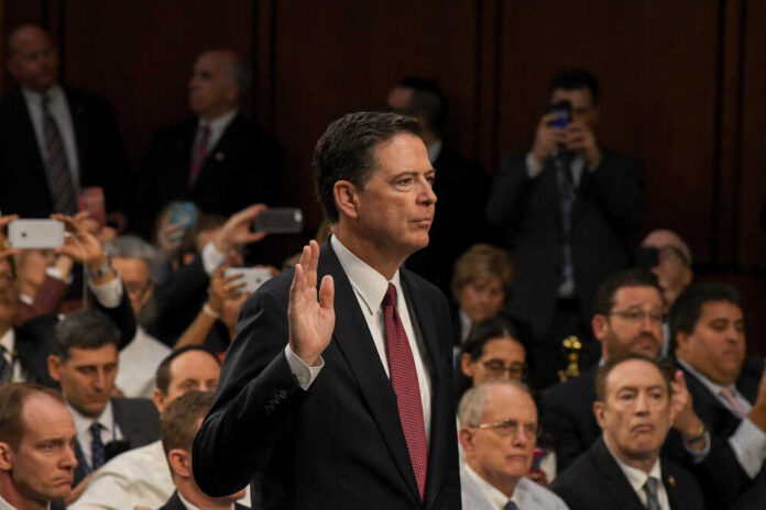 A man raising his right hand in a congressional hearing setting