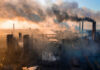Industrial facility with smoking chimneys under a colorful sky