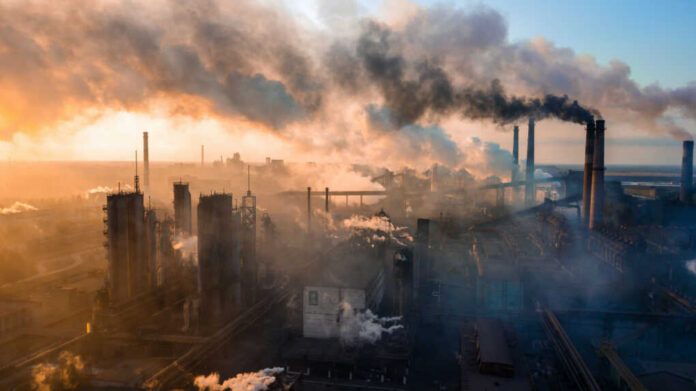 Industrial facility with smoking chimneys under a colorful sky