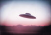 UFO flying over mountains during sunset or sunrise