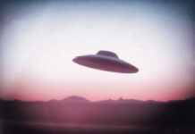 UFO flying over mountains during sunset or sunrise