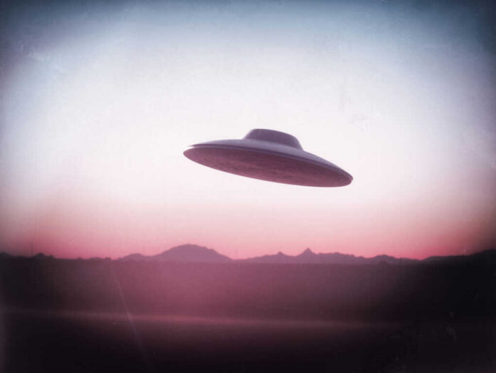 UFO flying over mountains during sunset or sunrise