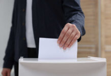 Ukrainian Cash Frenzy: $1.4B Election Mystery! Hand placing a ballot into a box