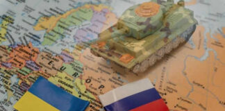 Toy tank with Ukraine and Russia flags on map.