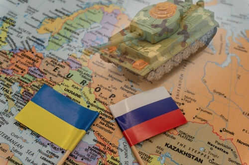 Toy tank with Ukraine and Russia flags on map.