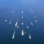 Aerial view of multiple naval ships operating in the ocean