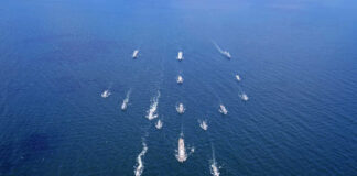 Aerial view of multiple naval ships operating in the ocean
