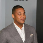 Man in a gray suit smiling at an event