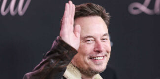 Man in leather jacket smiling and waving
