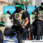 Masked men with firearms standing on a vehicle