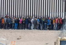Courtroom Showdown Upends Border Crackdown Large group of people standing near border fence