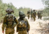 Soldiers walking in formation along a sandy path
