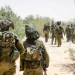 Two Allies Down — Internet Spins A War Soldiers walking in formation along a sandy path