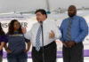 Three people speaking at a promotional event.