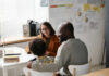 Parents Bypassed — Who’s Actually In Charge? Three people sitting at a desk talking together