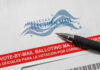 Mail-in ballot envelope with pen