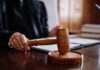 After Years Of Fighting — Rifle Returns A judge's hand holding a gavel in a courtroom setting