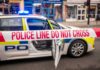Police car with a 'Do Not Cross' tape in front