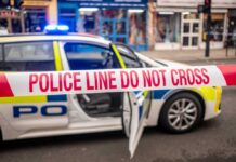 Police car with a 'Do Not Cross' tape in front