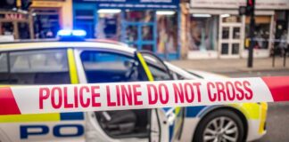 Police car with a 'Do Not Cross' tape in front