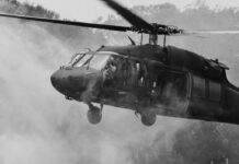 Hormuz Flashpoint: Apache Down, Tempers Up Military helicopter hovering with soldiers at open door
