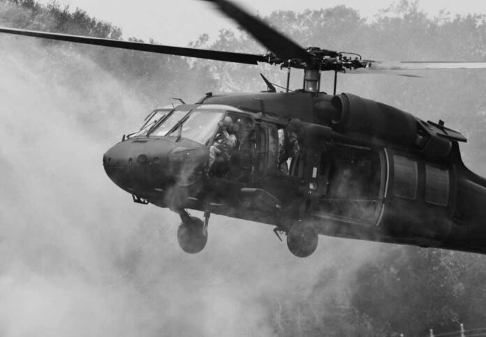 Military helicopter hovering with soldiers at open door
