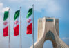 Censorship Fight Erupts at World Cup Venue Three Iranian flags in front of the Azadi Tower against a blue sky