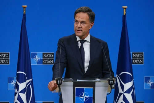 mark-rutte-2524491683 Man speaking at podium with NATO flags behind him