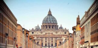 St. Peter's Basilica viewed from a busy street with crowds
