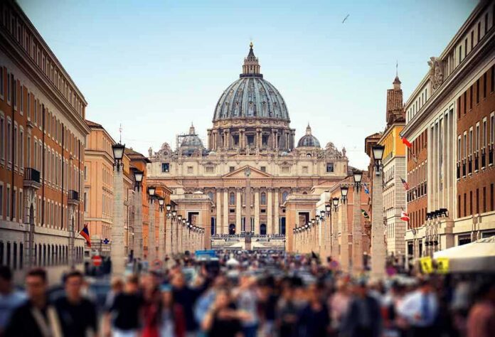 shutterstock_1503131939 St. Peter's Basilica viewed from a busy street with crowds