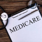A document labeled 'Medicare' with a stethoscope and magnifying glass on a wooden surface