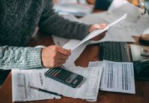 Free Breathing Room—Or Debt Bomb? Person reviewing bills with calculator at cluttered desk